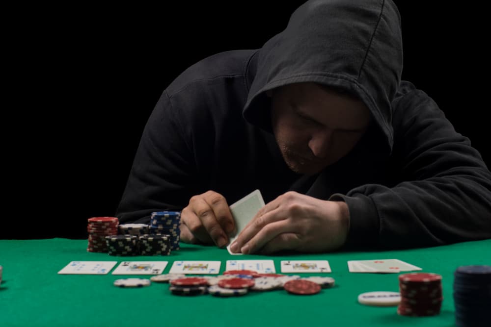man looking down at poker cards